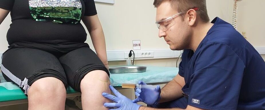 An orthopedic doctor makes an intra-articular injection into the knee joint for osteoarthritis